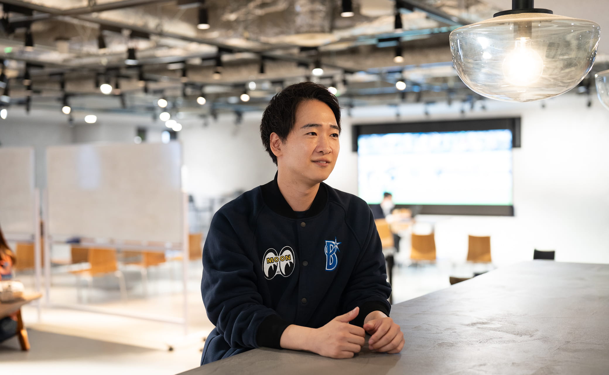 座って右を向いてインタビューを受ける男性